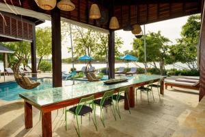 a dining room with a table and chairs and a pool at The Enclave - Your Own Private Island Retreat in Placencia Village