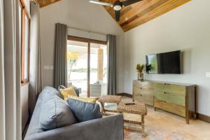 a living room with a couch and a tv at The Enclave - Your Own Private Island Retreat in Placencia Village