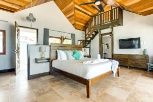 - une chambre avec un grand lit et un plafond en bois dans l'établissement The Enclave - Your Own Private Island Retreat, à Placencia