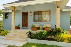 a home with a front porch with a door at The Enclave - Your Own Private Island Retreat in Placencia Village