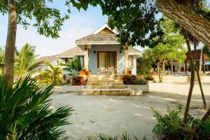 a house with stairs and trees in front of it at The Enclave - Your Own Private Island Retreat in Placencia Village