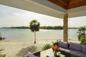 a view of the beach from the porch of a house at The Enclave - Your Own Private Island Retreat in Placencia Village