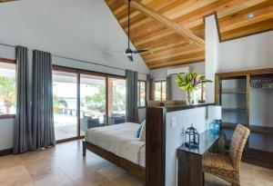 a bedroom with a bed and a desk at The Enclave - Your Own Private Island Retreat in Placencia Village