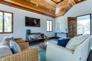 a living room with white furniture and wooden ceilings at The Enclave - Your Own Private Island Retreat in Placencia Village