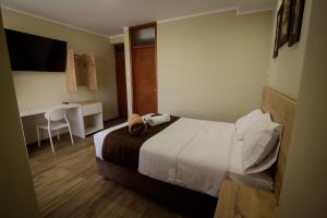 a hotel room with a bed and a desk at Hotel VILLA LUNA in Moquegua