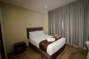 a hotel room with a bed with two towels on it at Hotel VILLA LUNA in Moquegua