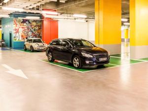 dos coches están estacionados en un estacionamiento en ibis Paris 17 Clichy-Batignolles, en París