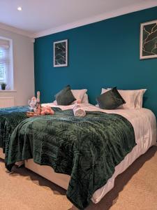 una camera con un grande letto con una parete blu di Woodland Green - BHX, NEC, HS2 a Marston Green