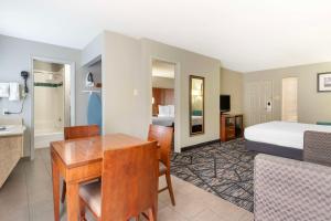 um quarto de hotel com uma cama e uma sala de jantar em Best Western near Lackland AFB Sea World em San Antonio
