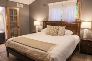1 dormitorio con 1 cama grande y 2 lámparas en Spacious Vacation Home, en Chanhassen