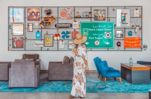 a woman in a straw hat standing in a living room at Rove City Centre, Deira in Dubai