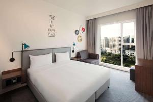 a bedroom with a large white bed and a window at Rove City Centre, Deira in Dubai