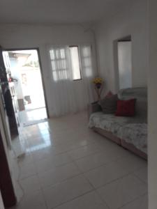uma sala de estar com um sofá e uma porta aberta em Casa para temporada no Guarujá