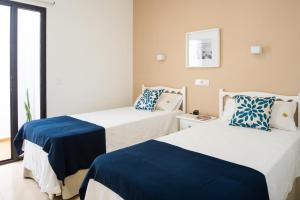 a bedroom with two beds with blue and white sheets at Delmar Natur - Sama in Charco del Palo