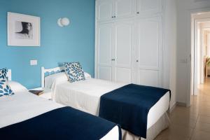 two beds in a room with blue walls at Delmar Natur - Mero in Charco del Palo