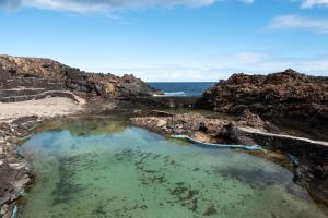 a pool of water on a rocky beach at Delmar Natur - Mero in Charco del Palo