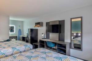 a hotel room with a bed and a desk at Studio 6 Jackson MS I 55 in Jackson +19 photos