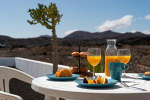 - une table avec deux verres de jus d'orange et de nourriture dans l'établissement Delmar Natur - Peje Verde, à Charco del Palo