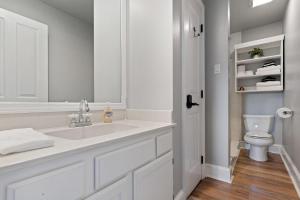 a white bathroom with a sink and a toilet at Quiet Retreat Off Magazine W Balcony & Parking! in New Orleans