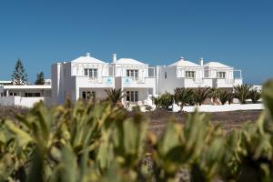 una gran casa blanca con árboles delante de ella en Delmar Natur - Gallo, en Charco del Palo