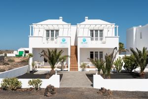 Un edificio blanco con palmeras delante. en Delmar Natur - Gallo, en Charco del Palo 10 fotos más