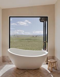 a bath tub in a bathroom with a large window at Rest Private Escape at BoxGrove in Bathurst