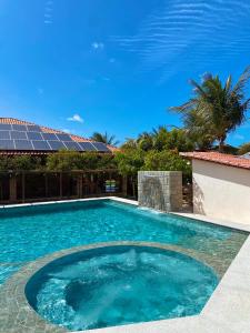 a swimming pool in front of a house at Chacara do Alemao in Flecheiras