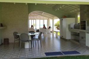 eine Küche und ein Esszimmer mit einem Tisch und Stühlen in der Unterkunft Pé na areia, casa beira-mar, Guarajuba in Guarajuba