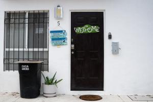 a black door with a welcome sign on it at Casa Aurora in Cancún