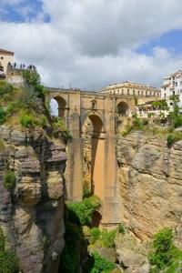 un puente al lado de una montaña rocosa en Céntrico Apartamento en Ronda, en Ronda