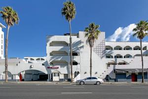 a car parked in front of a building with palm trees at SoMa House in San Francisco