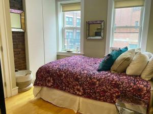 una camera da letto con un letto con cuscini sopra di Boston Harbor views Modern north end condo FREE PARKING! a Boston