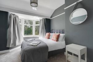 - une chambre avec un lit et un miroir dans l'établissement Charming 3BD Home Didsbury House, à Manchester