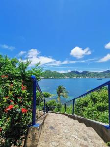 a view of the ocean with a blue railing at posada sunrise view vacation home in Providencia