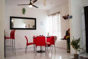 uma sala de jantar com cadeiras vermelhas e um espelho em Casa Aurora em Cancún