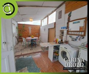 a kitchen with a table and a washing machine at RAMA GUEST HOUSE in Ciudad Lujan de Cuyo