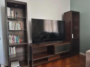 un centro de entretenimiento con TV de pantalla plana y estanterías de libros en Rio Belo, en Río de Janeiro