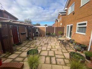 a patio with a table and chairs next to a building at Spacious 5 bedroom, 2 Living Room, Games Room in Wolverhampton