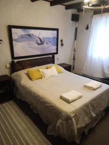 a bedroom with a large bed with two towels on it at El Molino in San Carlos de Bariloche