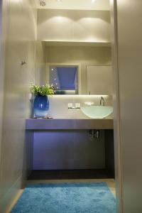 a bathroom with a sink and a vase with a plant at Baltic View Apartment in Dziwnówek +24 photos