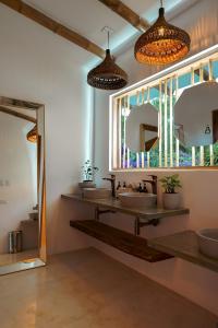 a bathroom with three sinks and two mirrors at Cannatel Exclusive Hotel in La Tebaida