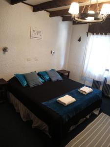 um quarto com uma cama grande e toalhas em El Molino em San Carlos de Bariloche