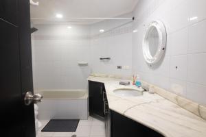 y baño con lavabo, bañera y espejo. en Apartamento edificio Exelaris, en Cartagena de Indias