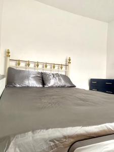 a bedroom with a large bed with a gold headboard at Elegant single-occupancy double bed room(1 person only) in Morriston