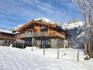 domek wiejski w śniegu z górami w tle w obiekcie Chalet Anna Leogang w mieście Leogang