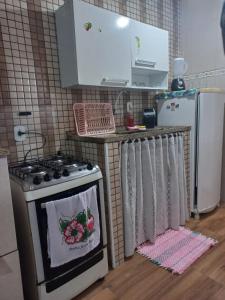 a kitchen with a stove and a refrigerator at Kitnet Arraial do Cabo, Monte Alto. in Arraial do Cabo