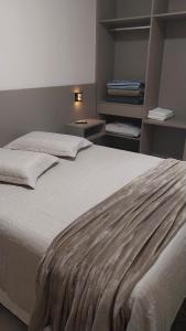 a large bed in a room with two nightstands at Flat's Da Bia in Cananéia