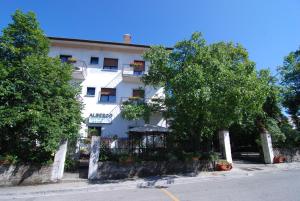 un edificio blanco con árboles delante de él en Albergo Alla Valle di Banne, en Trieste