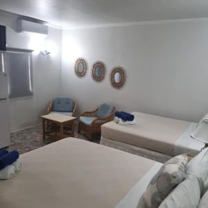 Habitación con 2 camas, mesa y sillas en Palm Beach Retreat, en Palm-Eagle Beach
