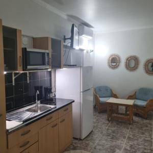 a kitchen with a sink and a refrigerator at Palm Beach Retreat in Palm-Eagle Beach